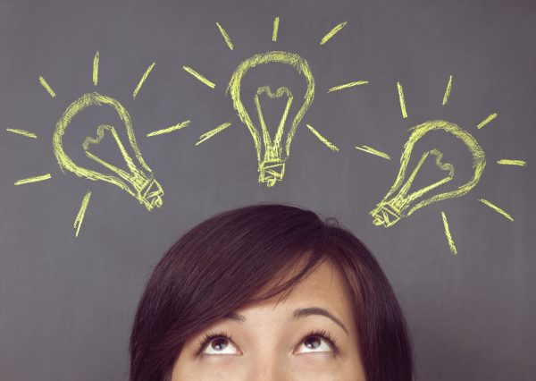 person looking up toward three lightbulbs