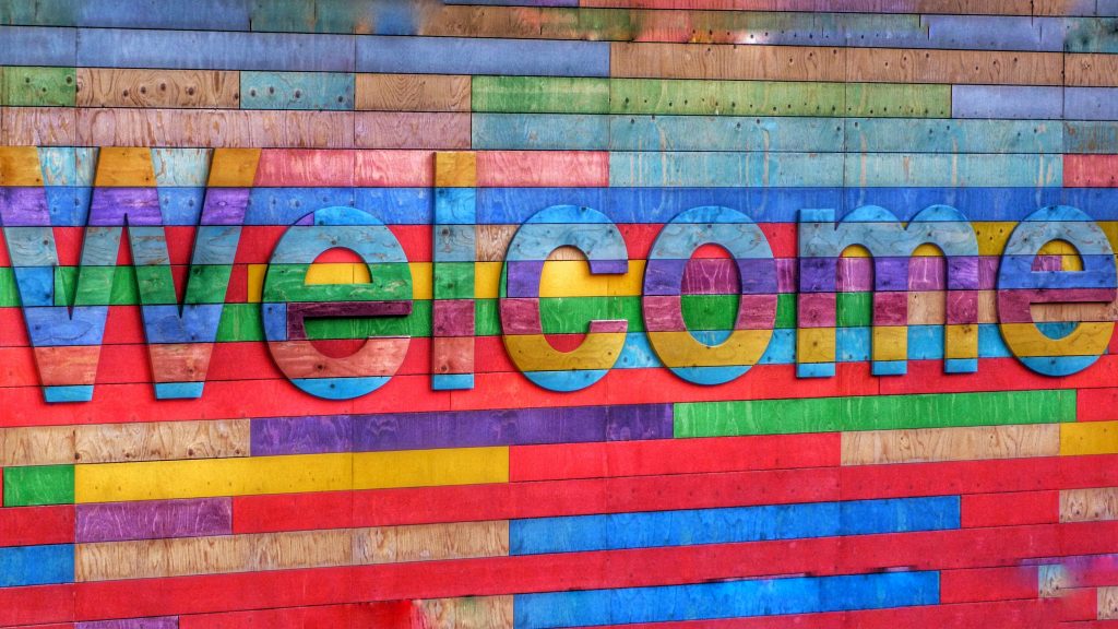 Sign made of multicoloured wooden panelsreading "Welcome".