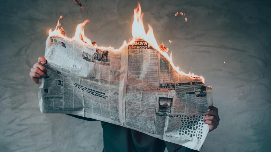 Man with newspaper on fire