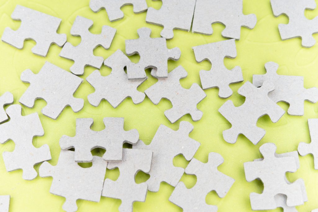 Blank cardboard puzzle pieces on a lemon yellow background