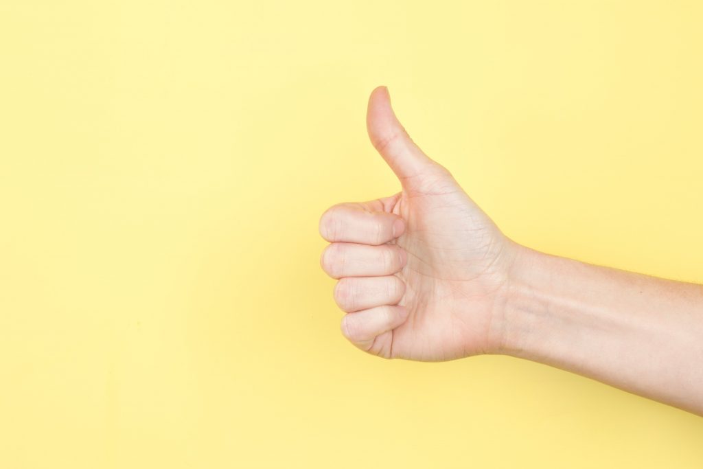 Thumbs up on yellow backdrop