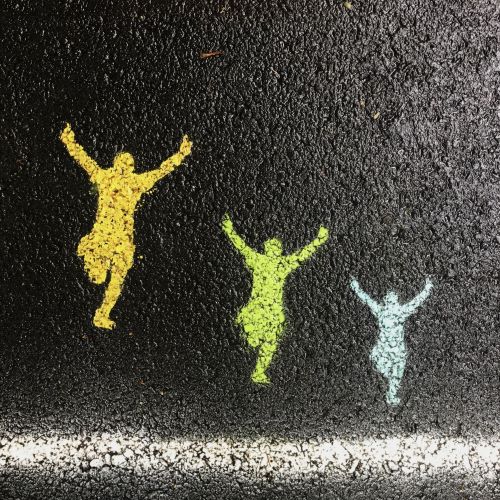 Start line on tar road with spray painted figures jumping in the air