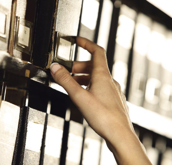 A hand reaching for Journals on Shelves in a Library