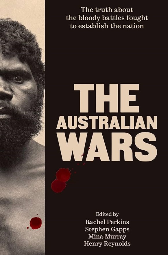 Cover art for The Australian Wars features an image of a First Nations man on the left hand side of the cover. Overlaid on his chest are red, blood-like splatters. The right side of the cover has a black background with the title in large, bold, capital letters. Above the title, smaller text reads "The truth about the bloody battles fought to establish the nation". At the bottom right of the cover, the editors are listed as Rachel Perkins, Stephen Gapps, Mina Murray and Henry Reynolds.